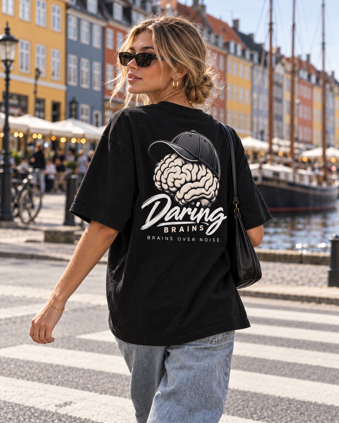 Chica con camiseta negra oversize Daring Brains con el logo en la espalda, junto a un canal